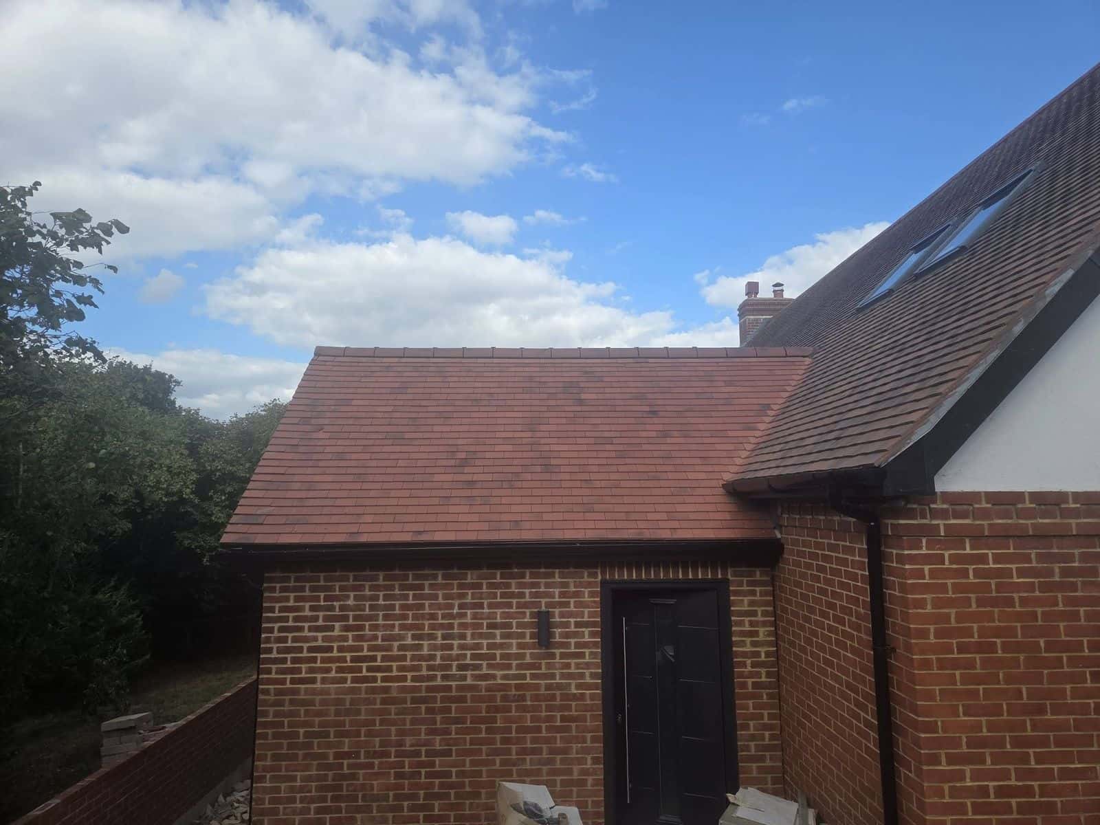 Newly tiled pitched roof on a brick extension